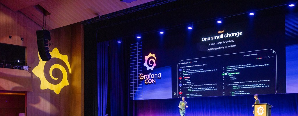 Nick and David on stage at GrafanaCON 2026, with a slide reading "One small change: a small change for Grafana, a giant opportunity for hackers"